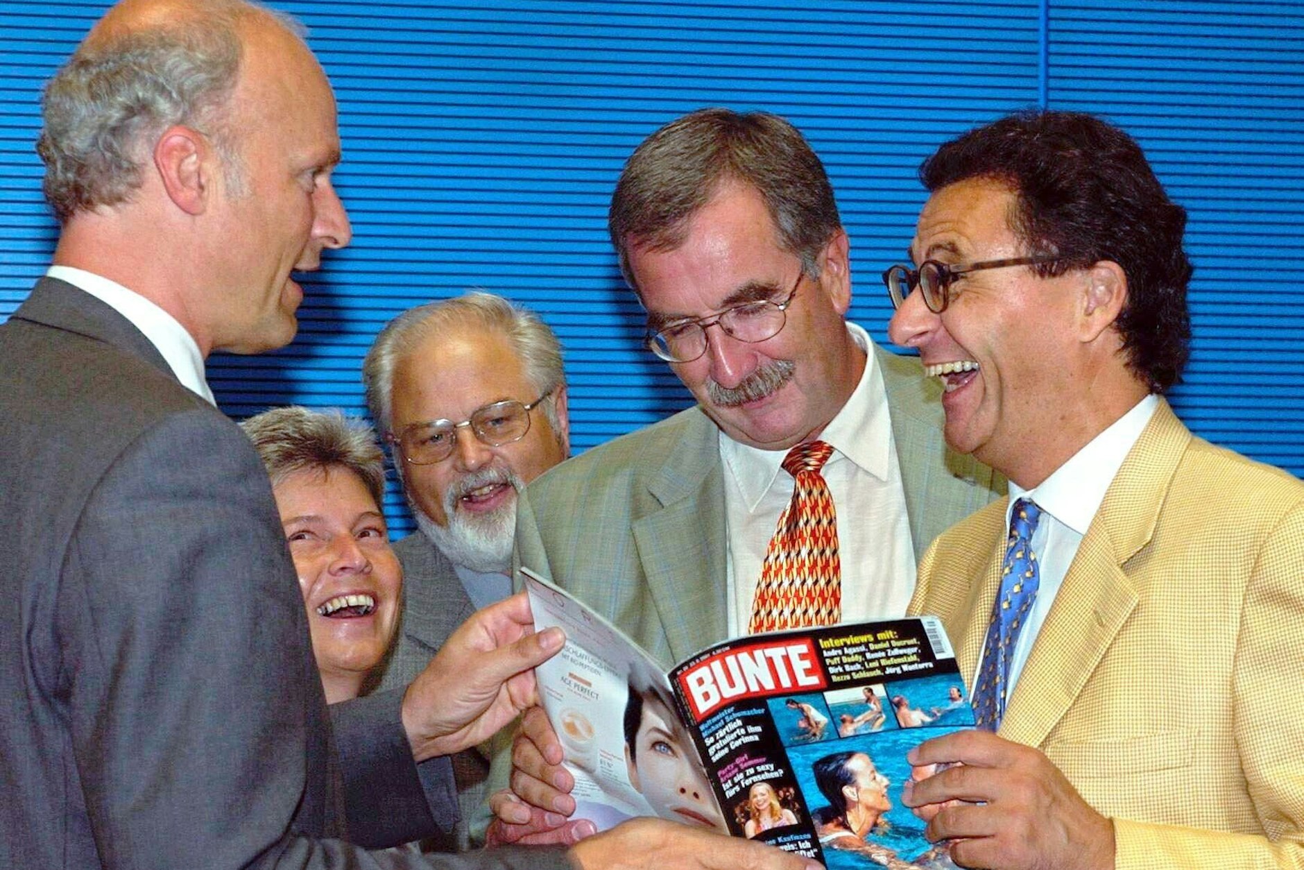 Lachend zeigt der frühere FDP-Abgeordnete Hans-Joachim Otto (r.) am 28. August 2001 seinen Fraktionskollegen einen Bericht der Illustrierten Bunte, der über den Urlaub von Ex-Verteidigungsminister Scharping und dessen Lebensgefährtin Gräfin Pilati berichtet.&nbsp;