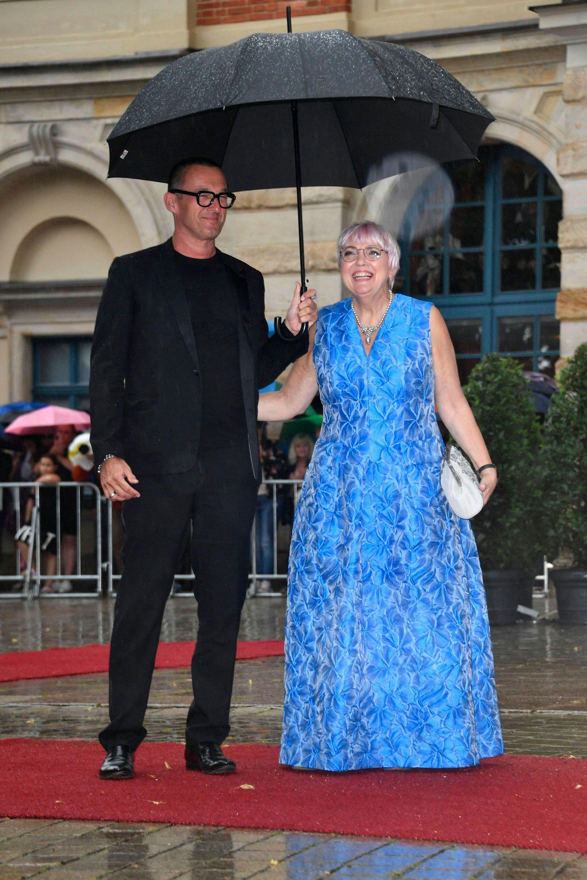 <strong>FLOP:</strong>&nbsp;Fast immer liegt <strong>Claudia Roth</strong> richtig. Die Frau hat ein Gefühl für Farbe, bringt neongrüne Schals nonchalant mit edlen Grau- und Beigenuancen zusammen, geht geschickt mit starken Pinktönen und intensivem Rot um. Auch für Qualitäten beweist die Staatsministerin für Kultur und Medien stets einen Sinn – ihre Kleidung wirkt hochwertig, außerdem voll von Witz und Eigensinn. Umso trauriger, dass sie auf dem roten Teppich der Bayreuther Festspiele nicht überzeugen konnte: Das mittelblaue Abendkleid wirkt befremdlich steif, sein Material scheint eher im Bereich der Heimtextilien angesiedelt. Ein bisschen sieht Frau Roth – pardon – wie ein Sitzmöbel aus, das sich auf den roten Teppich verirrt hat.
