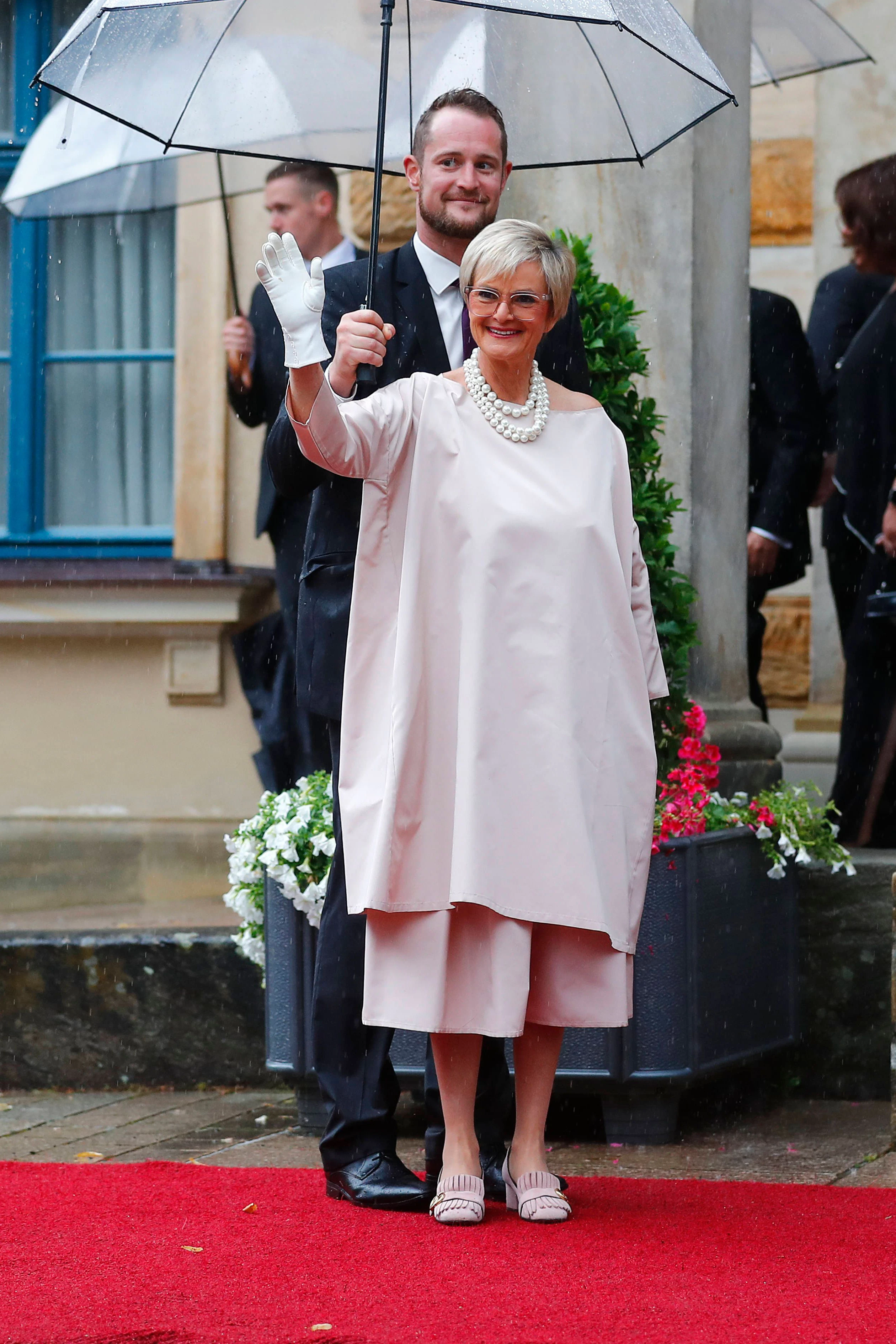 <strong>TOP:</strong> Ohnehin verfügt <strong>Gloria von Thurn und Taxis</strong>&nbsp;über ein recht avantgardistisches Können und stellt ganz sicher alle deutschen adligen Frauen mit der Wahl ihrer Garderobe und ihrem oft übergroßen und auffälligen Schmuck in den Schatten. Sie kann sich den unkonventionellen Look, für den sie schon in den 1980ern berühmt und oft berüchtigt war, durchaus leisten. Ihr roséfarbener Look steht ihr sowohl farblich als auch vom Schnitte her gut zu Gesicht, perfekt ergänzt durch ein mehrreihiges Perlencollier. Über die weißen Handschuhe lässt sich streiten, schnell sieht man damit aus wie Mickey Maus. Von Thurn und Taxis aber trägt das alles mit soviel Stilbewusstsein, dass man für ein paar Sekunden ihre oft kruden Statements zur allgemeinen Lage im Land und der Welt vergessen könnte.