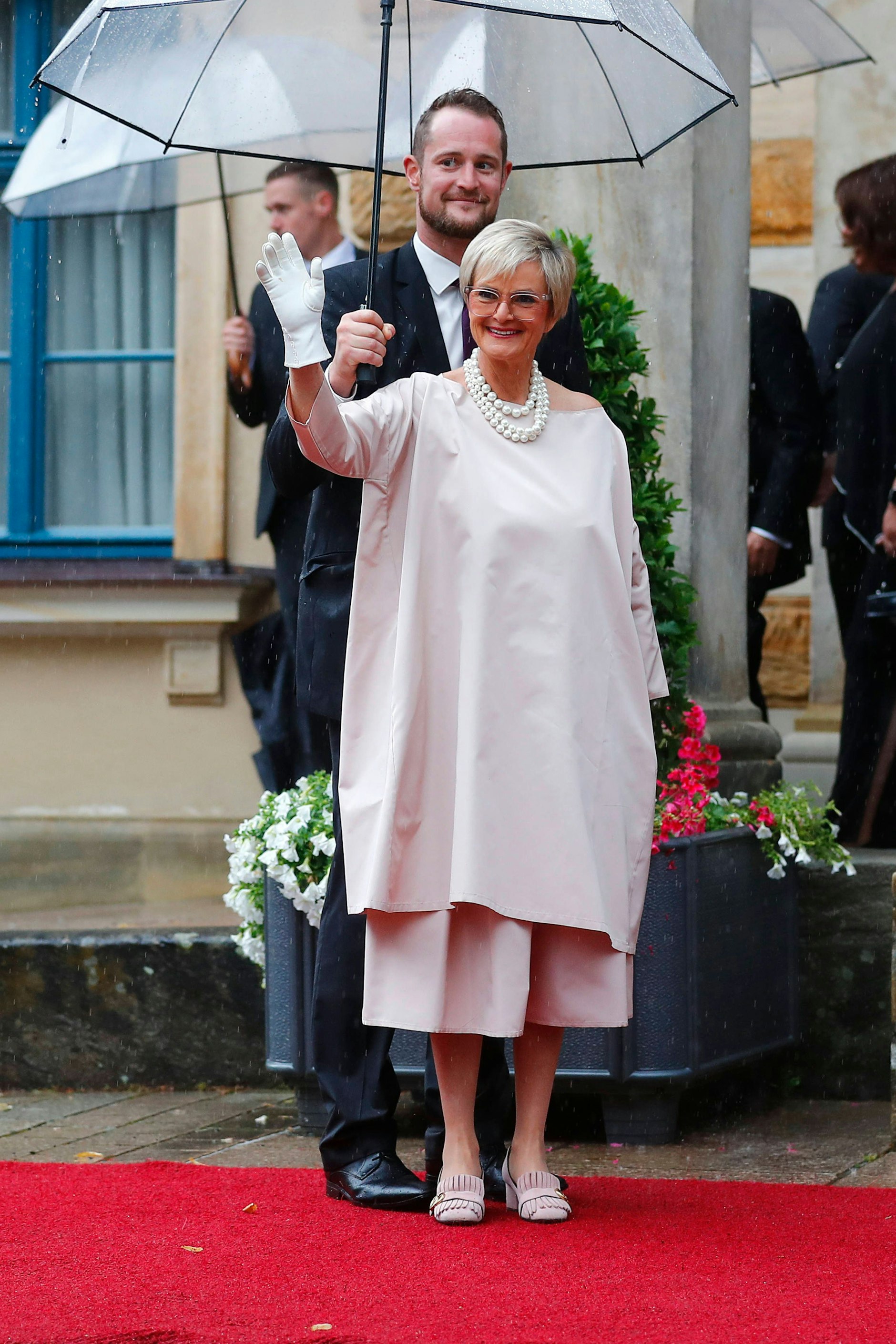 <strong>TOP:</strong> Ohnehin verfügt <strong>Gloria von Thurn und Taxis</strong>&nbsp;über ein recht avantgardistisches Können und stellt ganz sicher alle deutschen adligen Frauen mit der Wahl ihrer Garderobe und ihrem oft übergroßen und auffälligen Schmuck in den Schatten. Sie kann sich den unkonventionellen Look, für den sie schon in den 1980ern berühmt und oft berüchtigt war, durchaus leisten. Ihr roséfarbener Look steht ihr sowohl farblich als auch vom Schnitte her gut zu Gesicht, perfekt ergänzt durch ein mehrreihiges Perlencollier. Über die weißen Handschuhe lässt sich streiten, schnell sieht man damit aus wie Mickey Maus. Von Thurn und Taxis aber trägt das alles mit soviel Stilbewusstsein, dass man für ein paar Sekunden ihre oft kruden Statements zur allgemeinen Lage im Land und der Welt vergessen könnte.