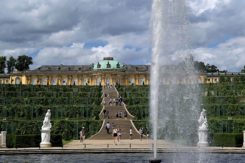 ARCHIV - Eine Fontäne sprüht Wasser in die Luft im Park vor Schloss Sanssouci.  
