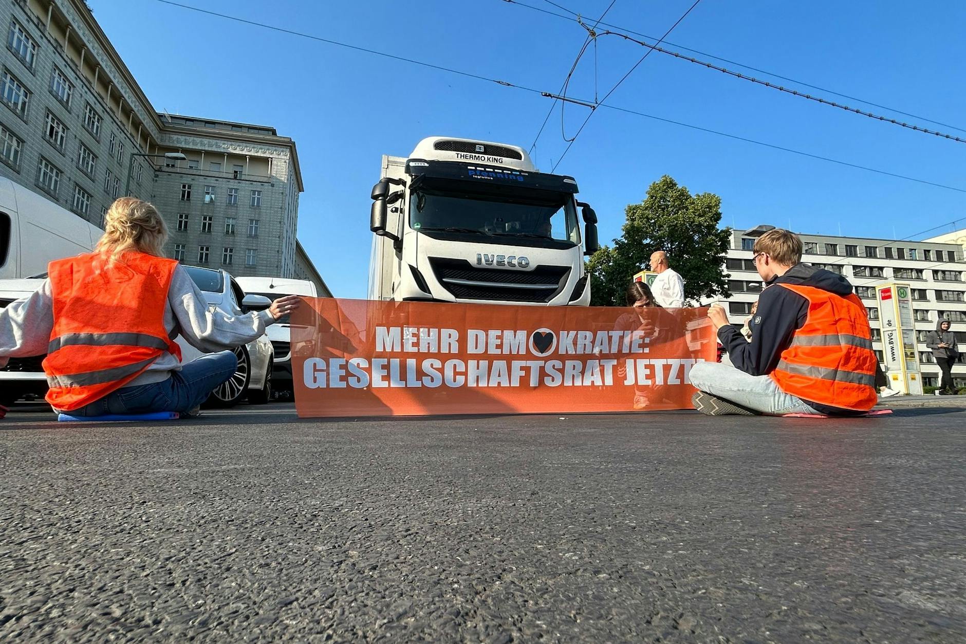 Aktivisten der Gruppe Letzte Generation blockieren eine Straße in Berlin. 