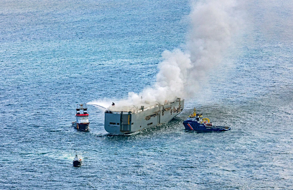 Eine Luftaufnahme zeigt einen deutschen Notschlepper(l), der das Feuer auf dem brennenden Frachter «Fremantle Highway» bekämpft.  rial photography/dpa