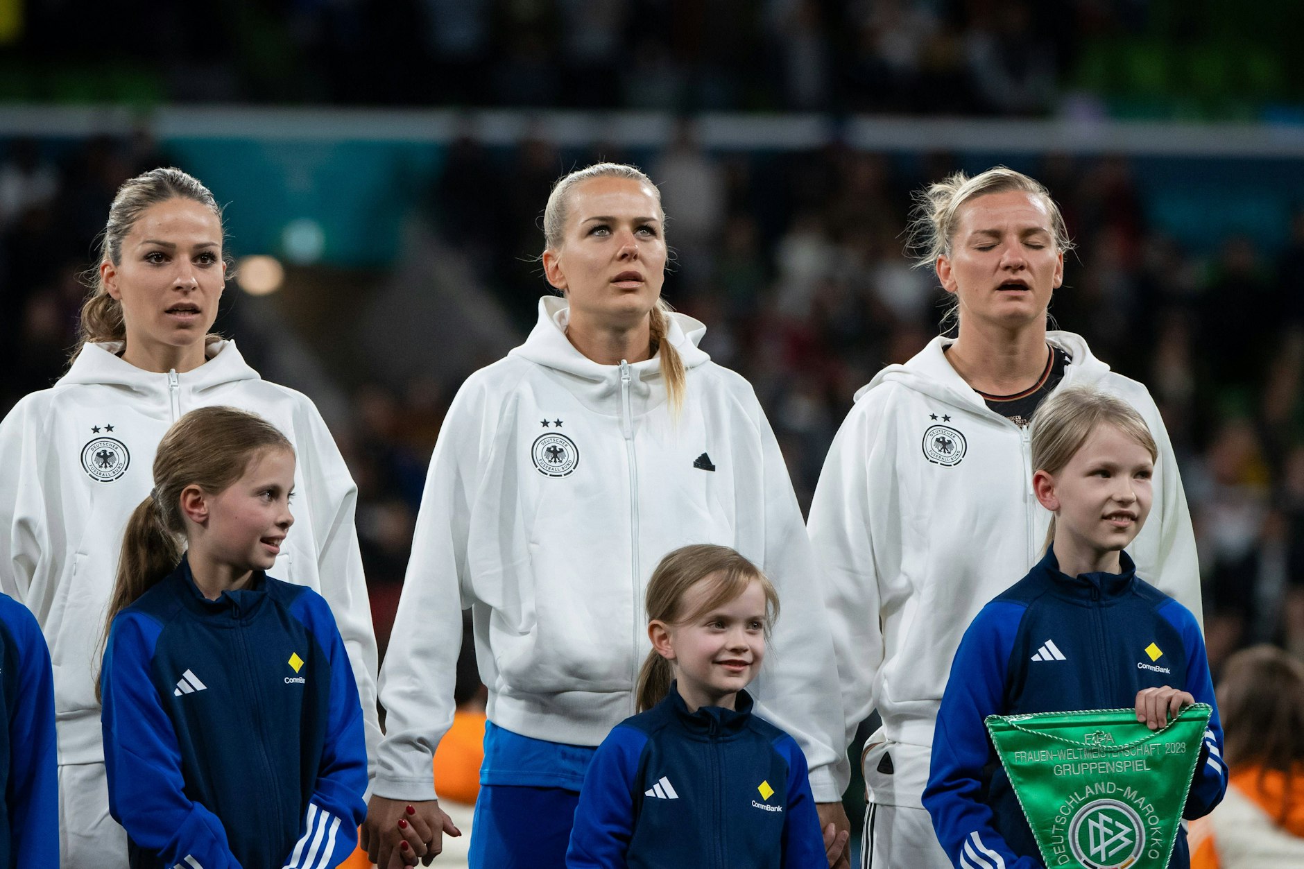Immer dieses Vaterland! Melanie Leupolz, Merle Frohms und Alexandra Popp (v.l.) beim Singen der deutschen Nationalhymne vor dem ersten Gruppenspiel der WM gegen Marokko.