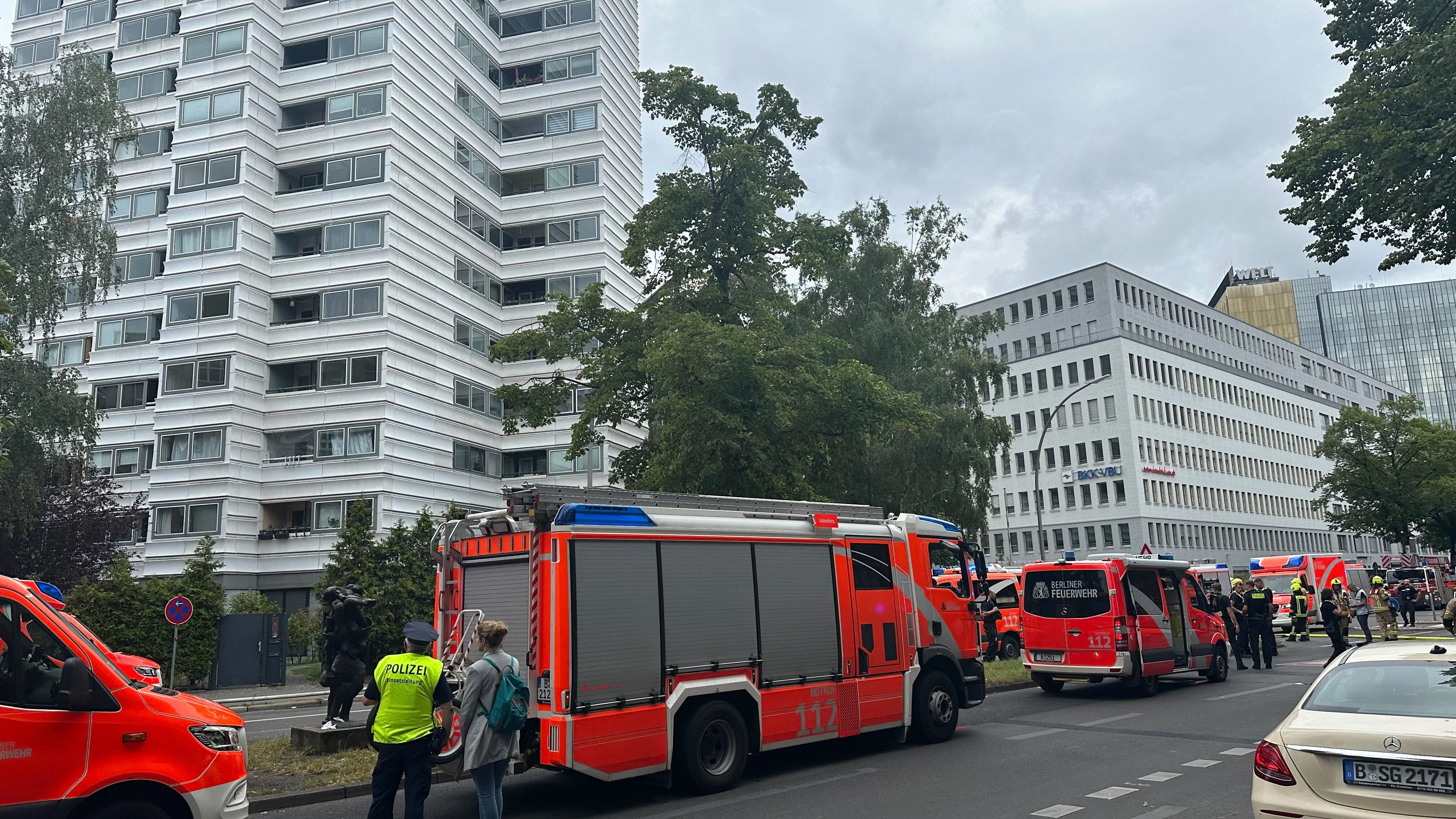 Einsatzkräfte vor dem Hochhaus. Zwei Menschen sind wegen eines Brandes in einem Hochhaus aus dem Gebäude gesprungen und gestorben.