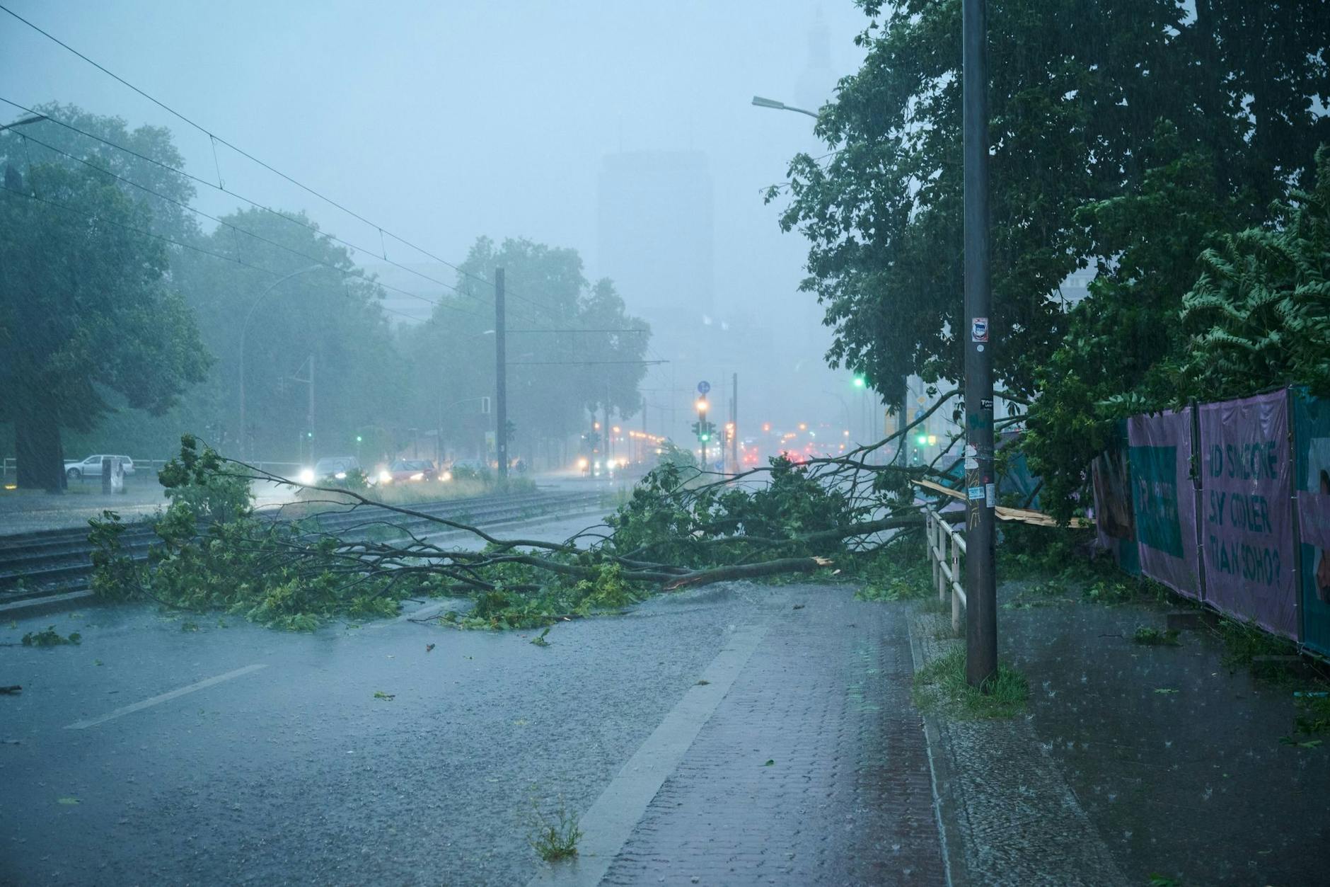 Starkregen hat einen Baum quer auf eine Straße stürzen lassen.