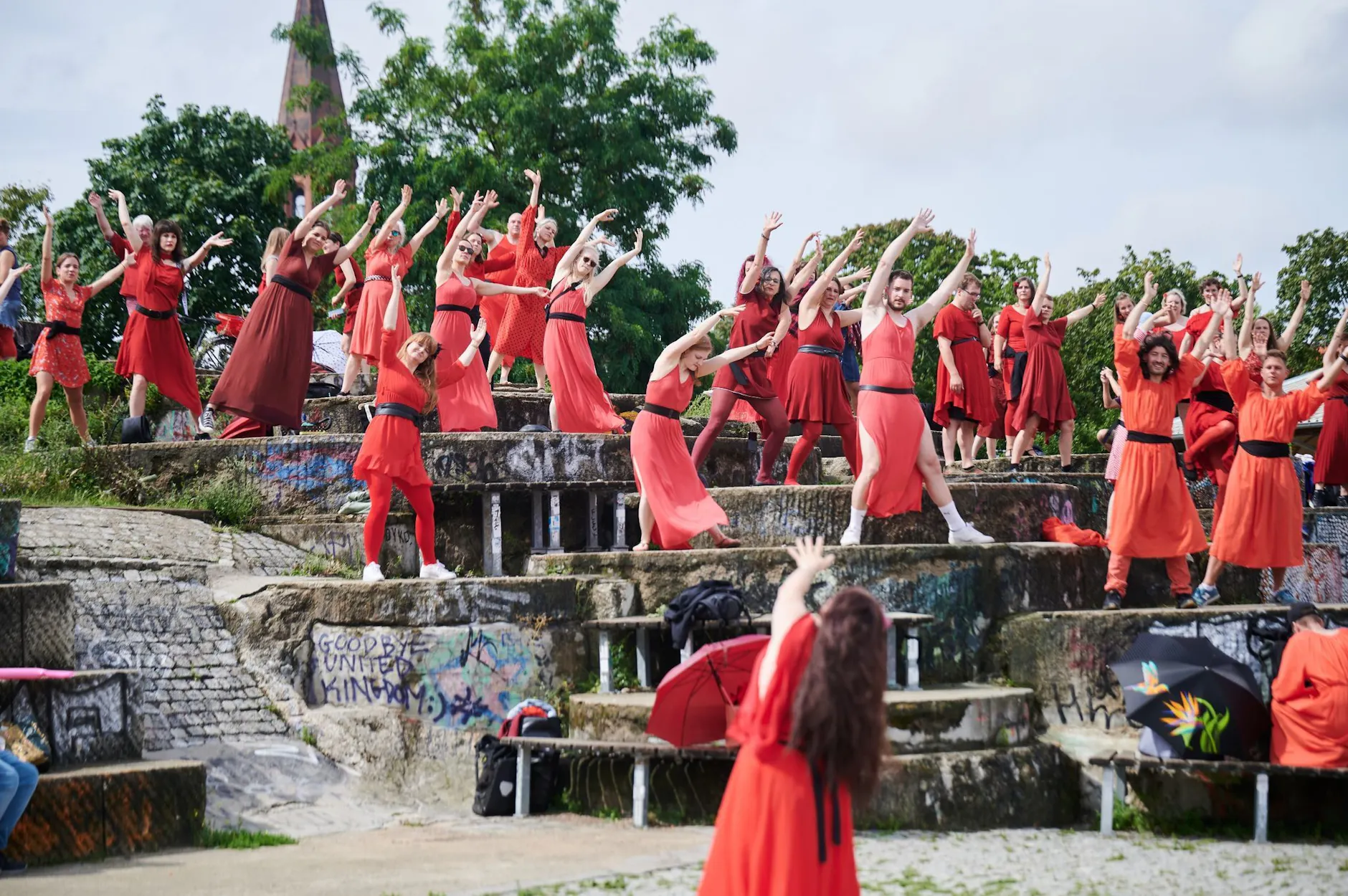 Frauen und Männer tanzen in Berlin die Choreografie aus einem Musikvideo von Kate Bush nach.