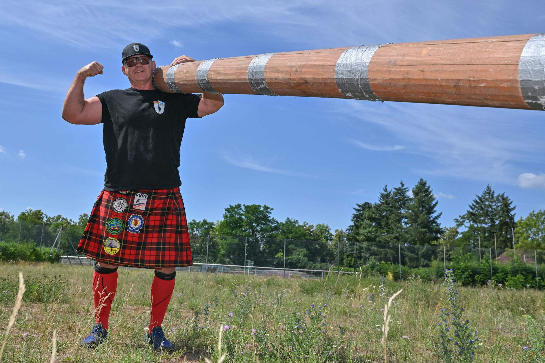 Brandenburg, Fürstenwalde: Hans-Dieter Dorow von den Stone Walker steht im Kilt auf dem Trainingsplatz in Fürstenwalde/Spree und hat auf seiner Schulter einen 50 Kilogramm schweren Baumstamm.