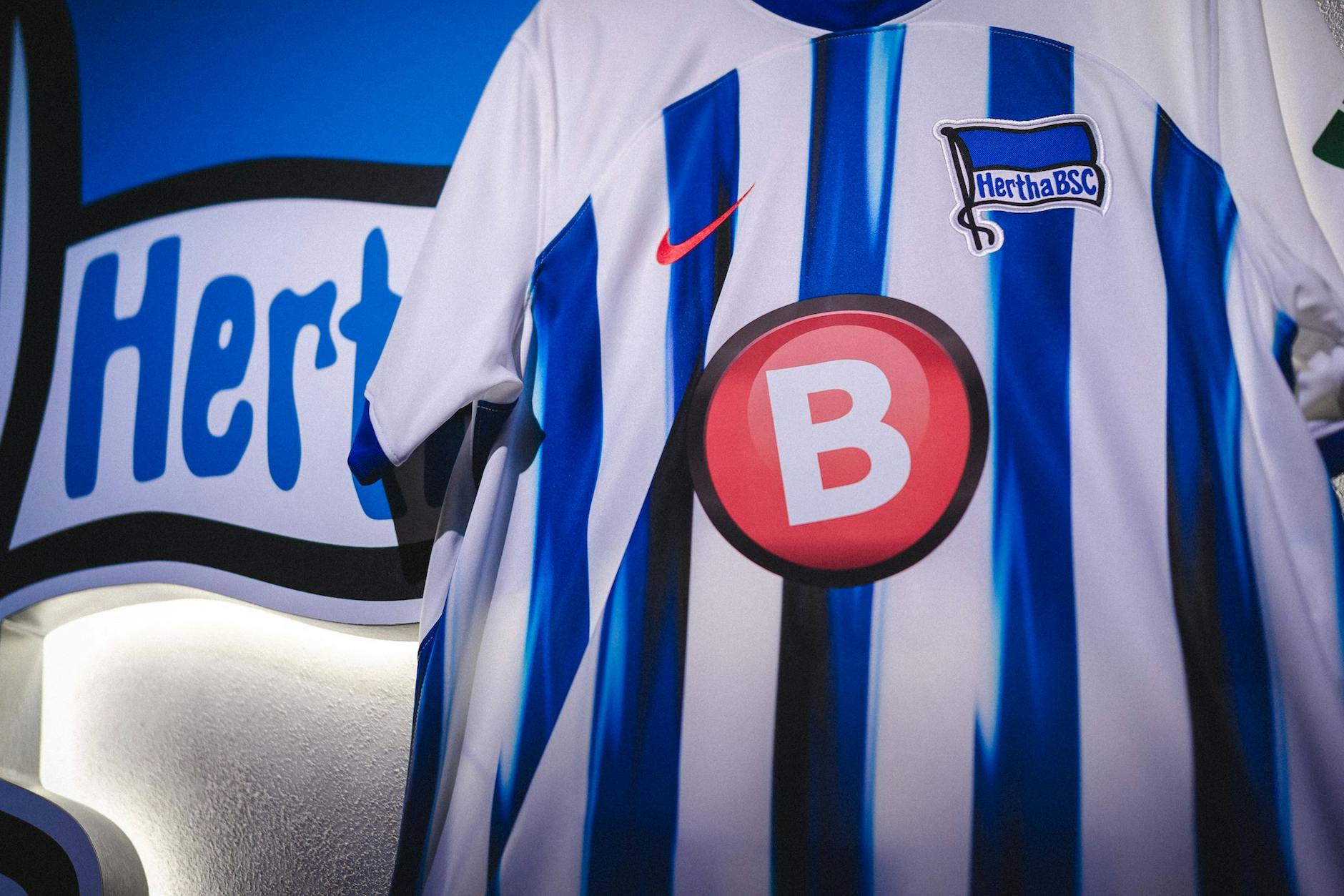 Ein großer roter Knopf mit einem dicken weißen B. Dieses Firmenlogo ziert jetzt Herthas Brust.
