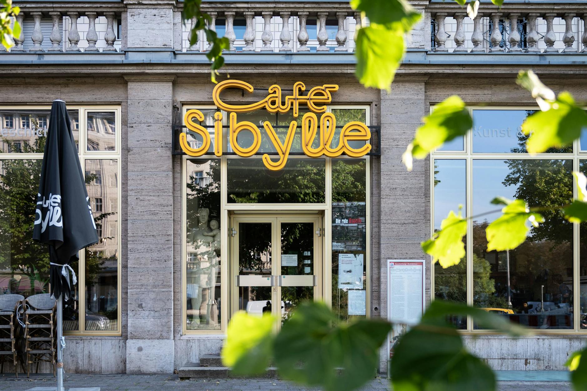 Das Café Sibylle in der Karl-Marx-Allee: links neben der Eingangstür eine Originalfigur aus dem Film „Das Leben der anderen“, rechts im Boden die Glasplatte, unter der einst ein Stadtmodell zu sehen war.
