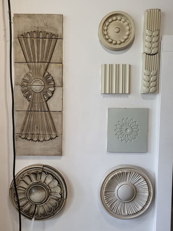 Eine Sammlung von Dekorelementen von den Bauten der Stalinallee, heute Karl-Marx-Allee. Links ein achtlos herabhängendes Kabel.