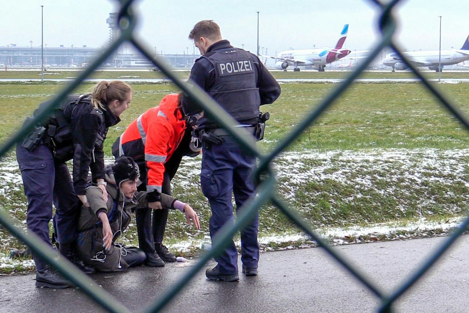 Bundespolizei und ein Sicherheitsmitarbeiter stehen mit einem sichergestellten Bolzenschneider an einem Zaun am BER-Flughafen. Aktivisten der Letzten Generation hatten versucht, auf das Rollfeld zu gelangen. (Archivbild)