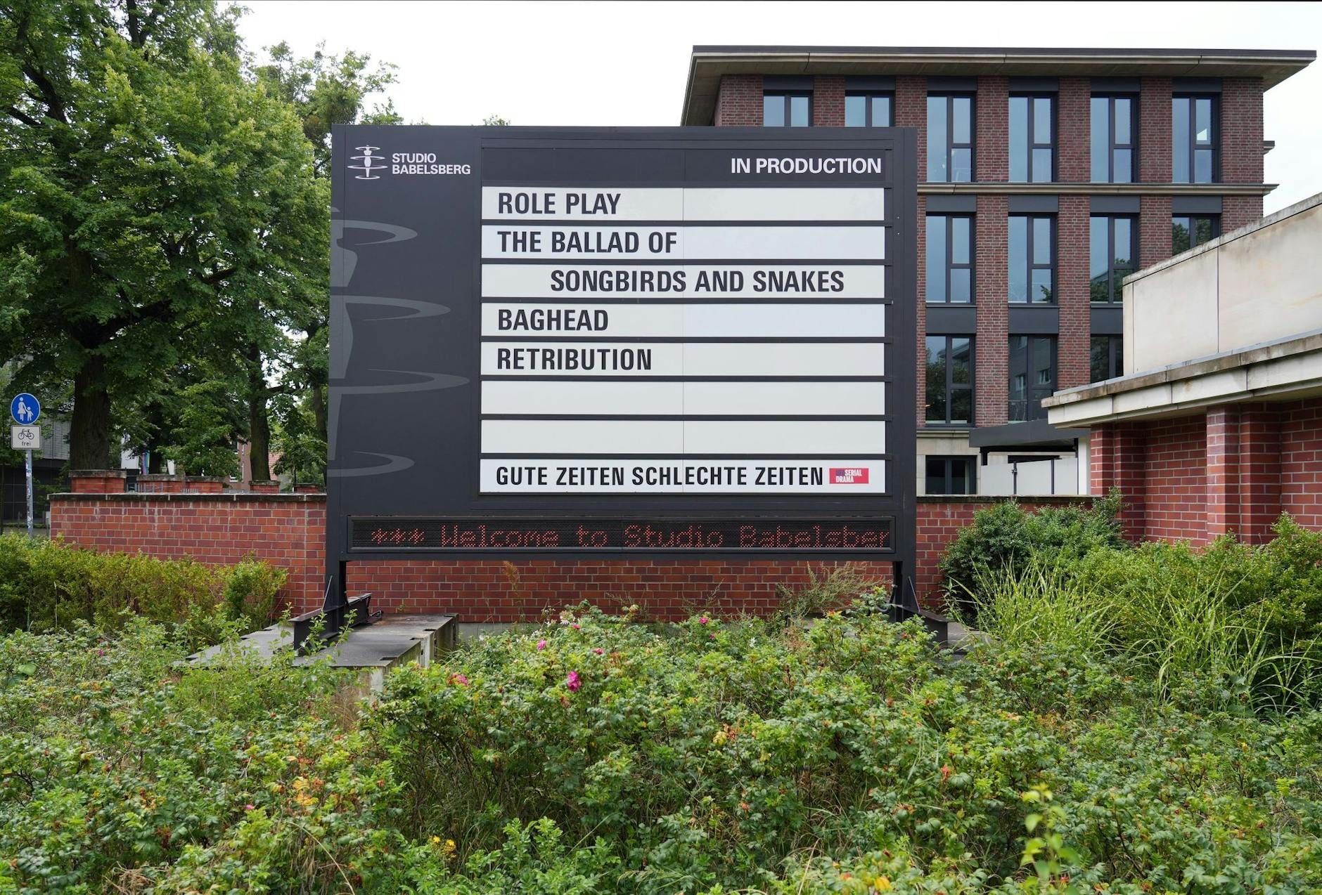 ARCHIV - Ein Display am Haupteingang zum Studio Babelsberg informiert über die Produktion verschiedener Filme und Serien.