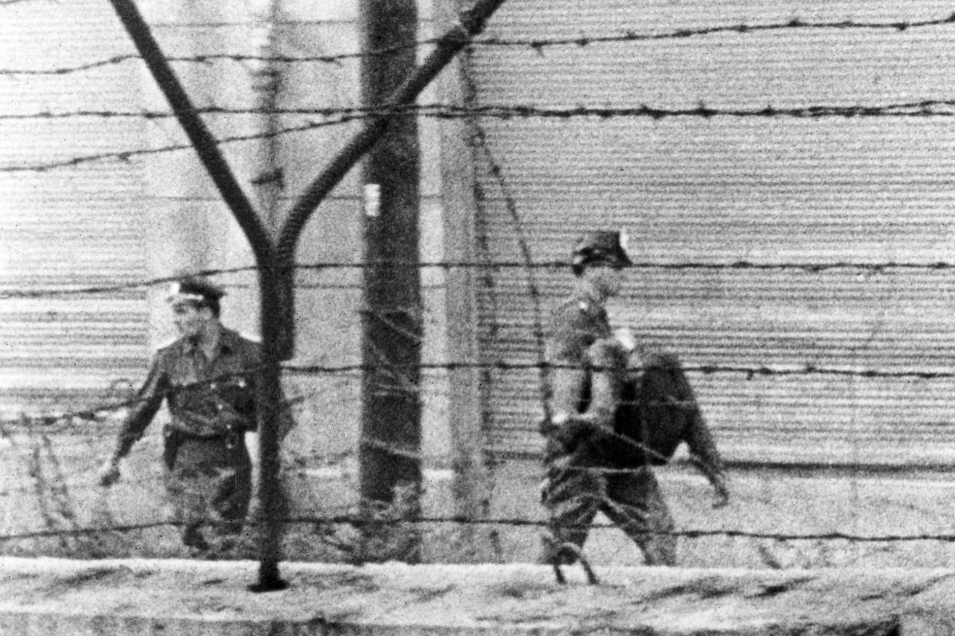 Zwei DDR-Volkspolizisten bringen am 17. August 1962 den Leichnam von Peter Fechter über die Zimmerstraße weg von der Berliner Mauer.