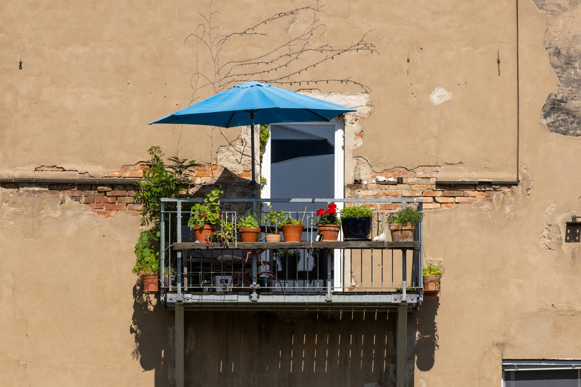 Leerer Balkon mit Sonnenschirm im Sommer.