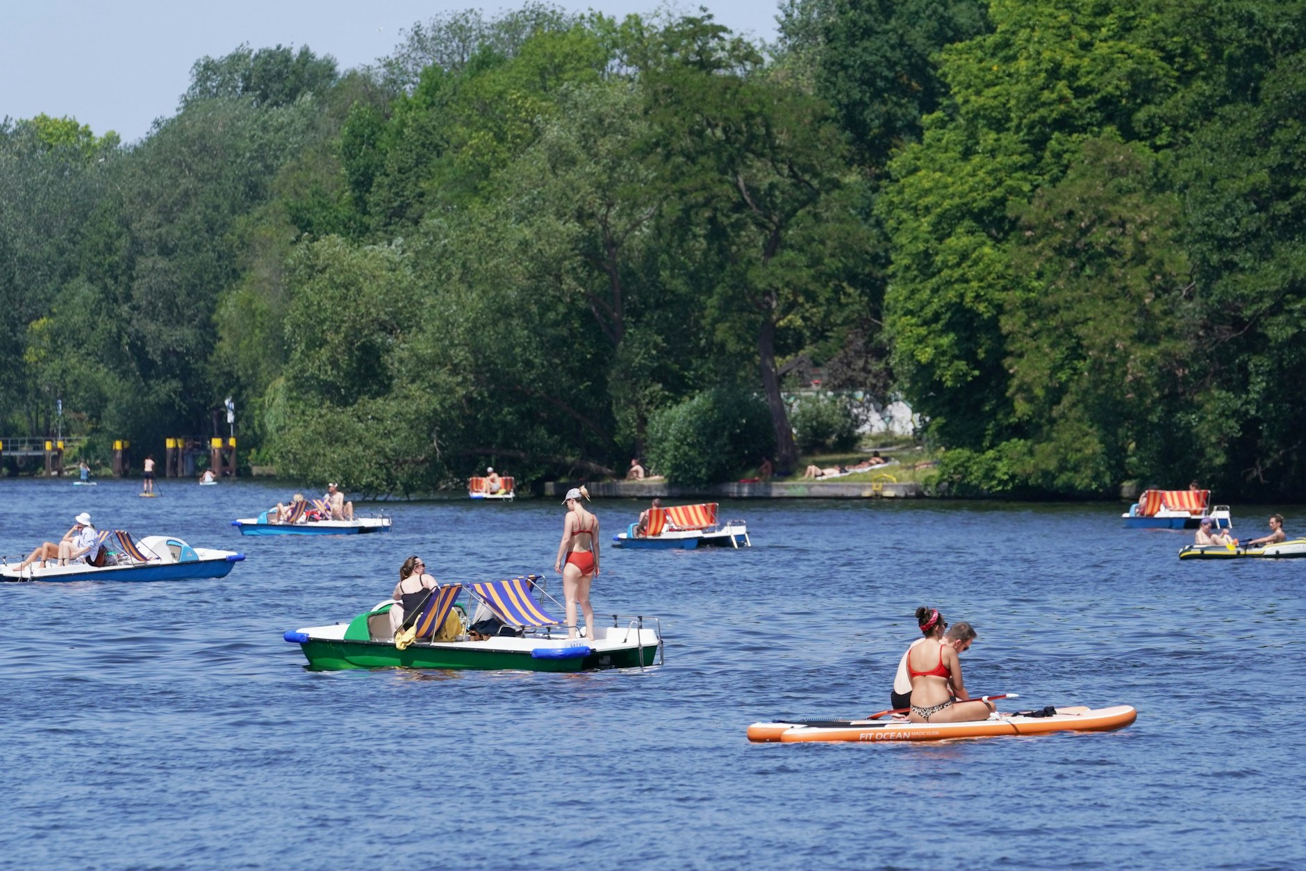 Zahlreiche Menschen verbringen ihre Zeit bei hochsommerlichen Temperaturen auf der Spree.