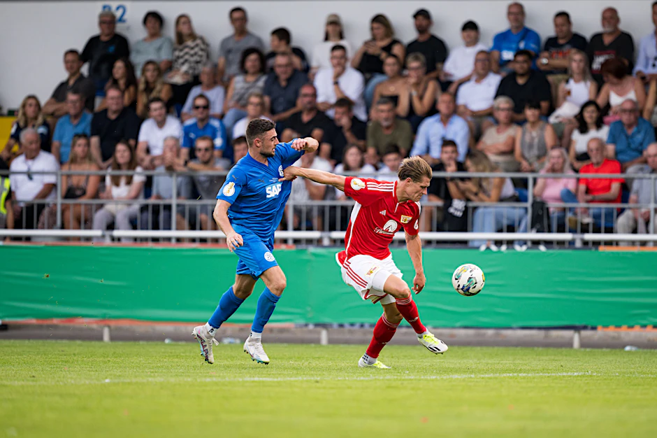 Kevin Behrens vom 1. FC Union hält Laurin Stich vom FC Astoria Walldorf auf Abstand.