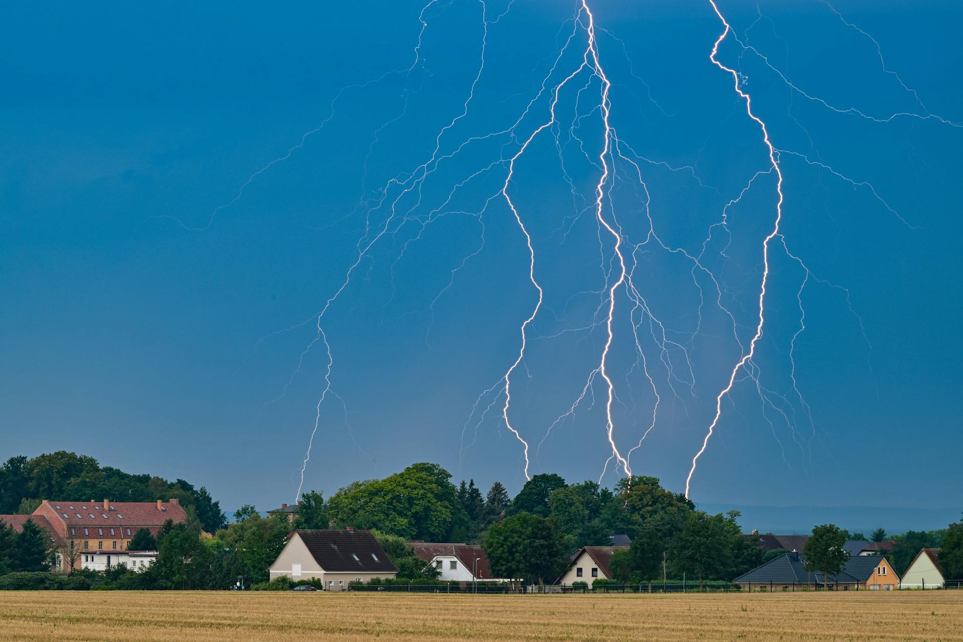 Blitze eines Gewitters leuchten am Abendhimmel im Osten von Brandenburg.