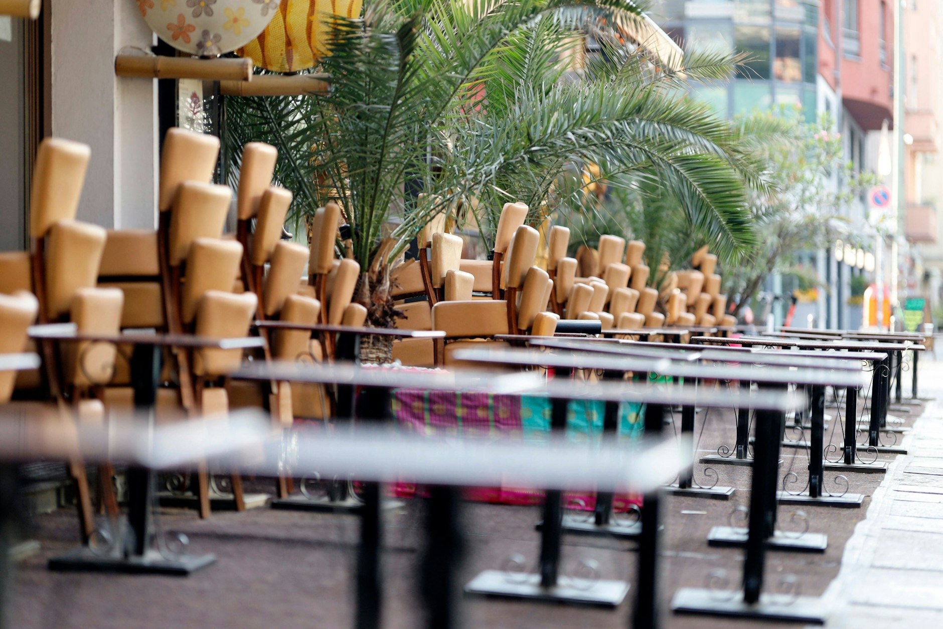 Leere Sitzbänke und hochgestellte Stühle stehen vor einem Restaurant (Symbolbild).