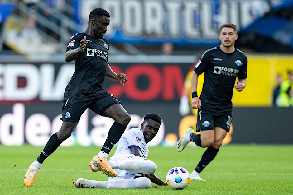 Paderborns Sirlord Conteh (l.) und Osnabrücks Maxwell Gyamfi kämpfen um den Ball.  