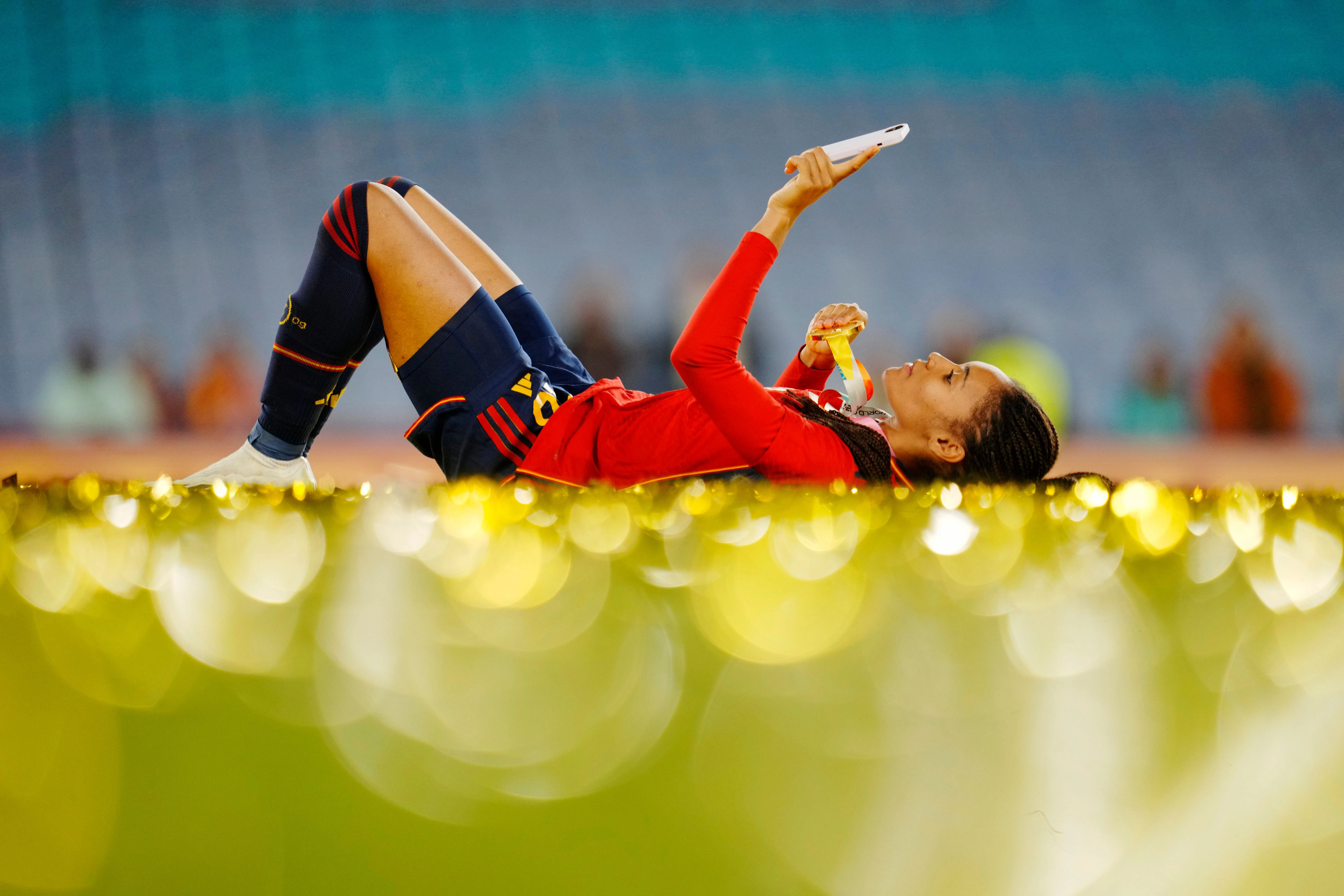 Salma Paralluelo liegt mit ihrer Medaille nach dem Spiel auf dem Rasen.