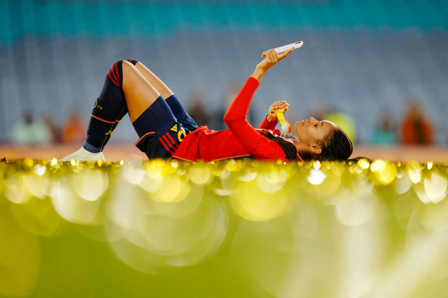 Salma Paralluelo liegt mit ihrer Medaille nach dem Spiel auf dem Rasen.