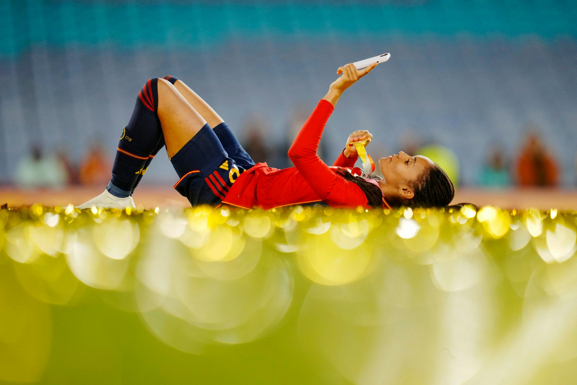 Salma Paralluelo liegt mit ihrer Medaille nach dem Spiel auf dem Rasen.
