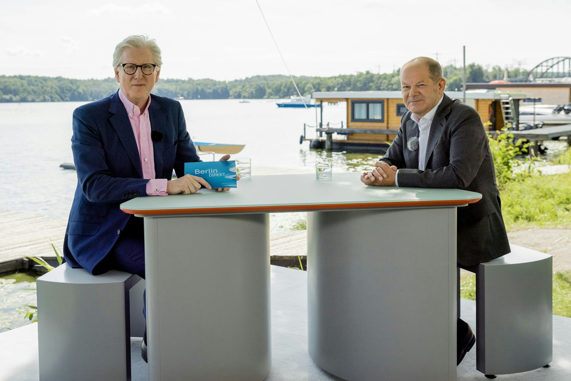 Da hilft auch das schöne See-Setting nichts: Bundeskanzler Olaf Scholz (SPD) sitzt am 13. August mit Theo Koll am bräsig-grauen Tischchen.