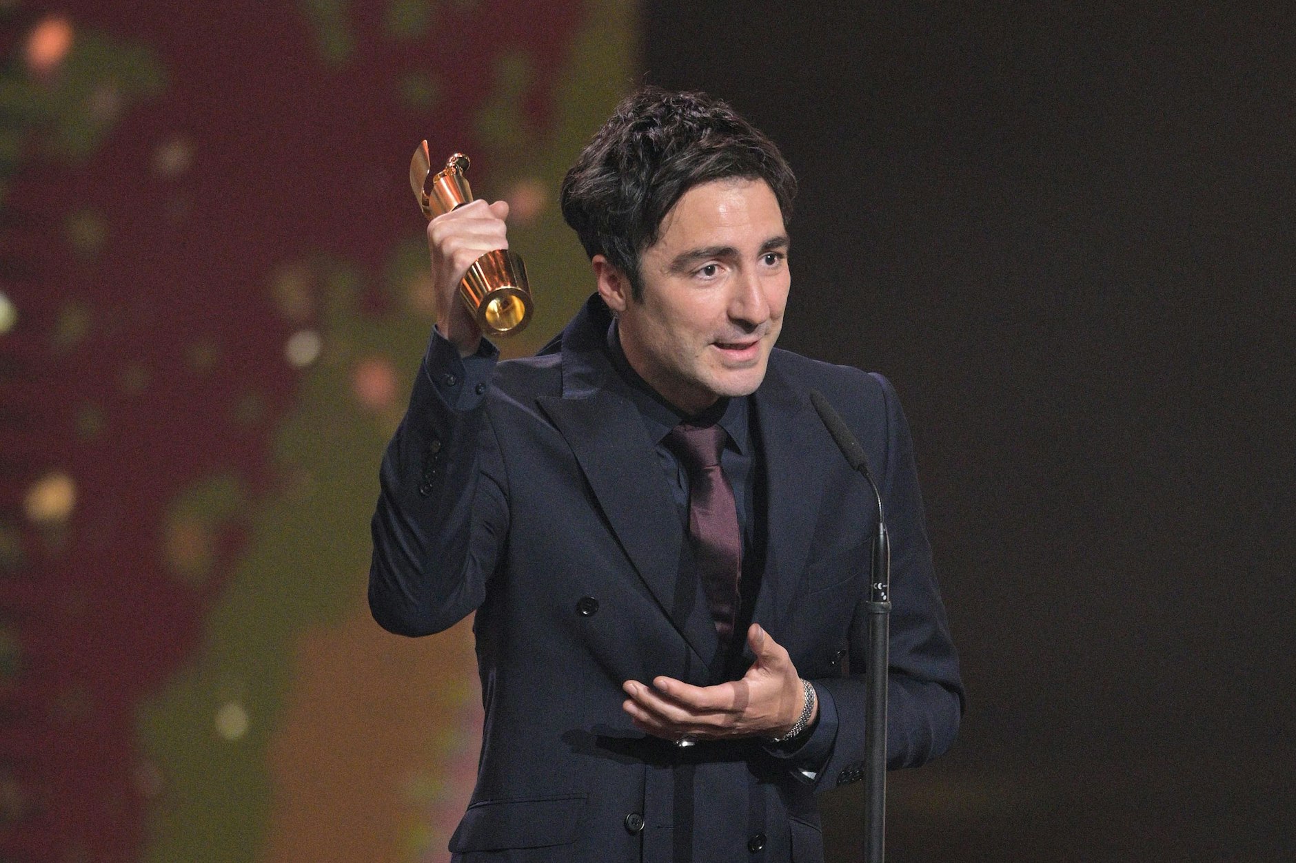Ilker Catak steht bei der Verleihung des Deutschen Filmpreises mit dem Preis für die beste Regie für „Das Lehrerzimmer“ auf der Bühne. 