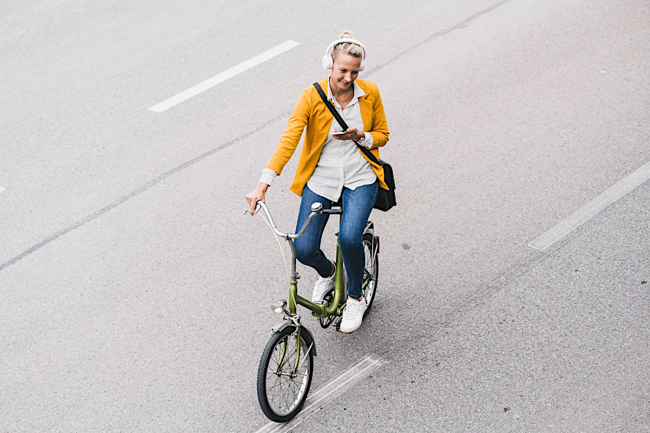 Nicht ganz bei der Sache: Eine Fahrradfahrerin schreibt SMS und hört Musik beim Fahrradfahren.&nbsp;