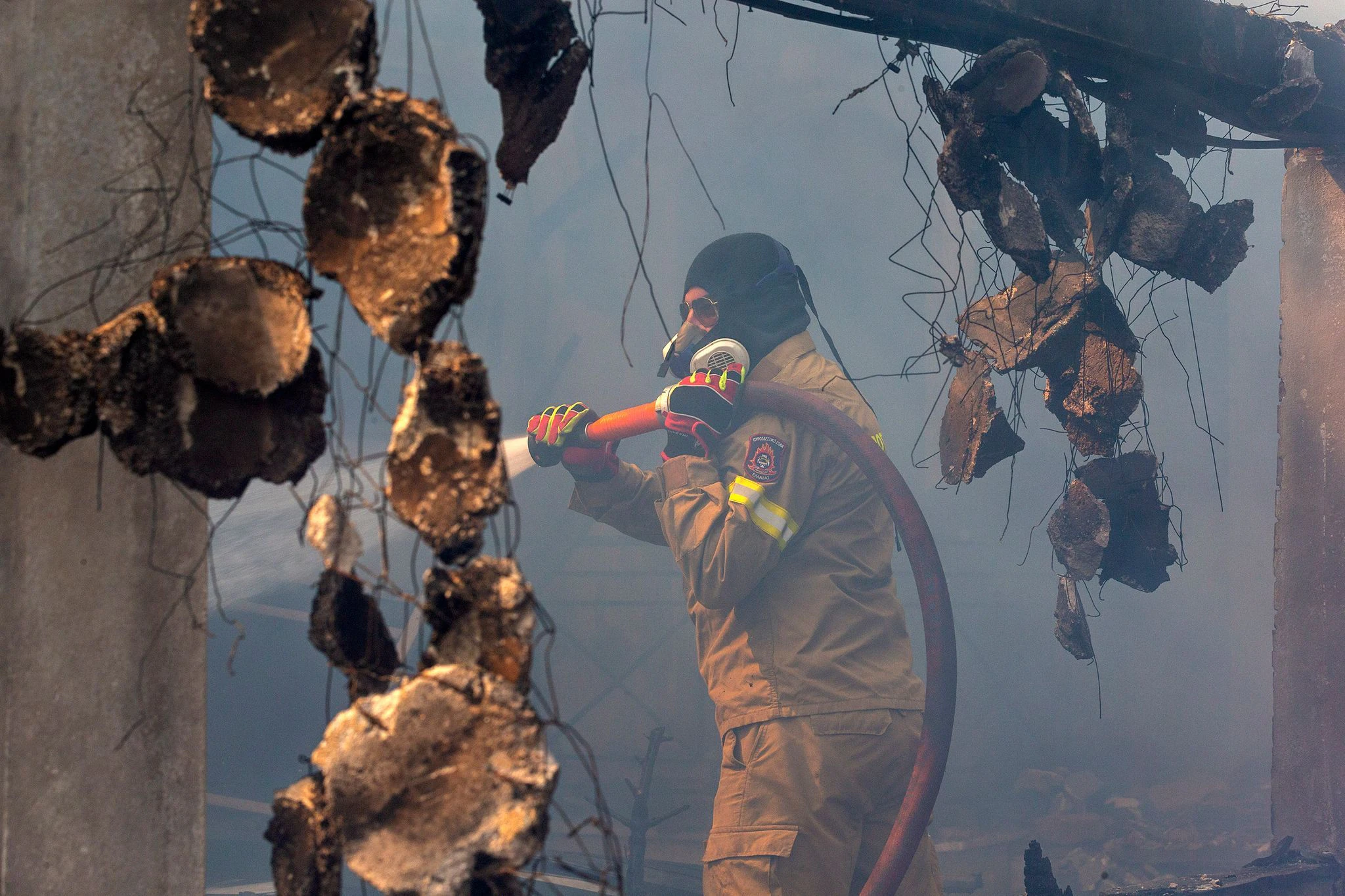 Ein Feuerwehrmann bekämpft einen Waldbrand in der Nähe von Athen.  