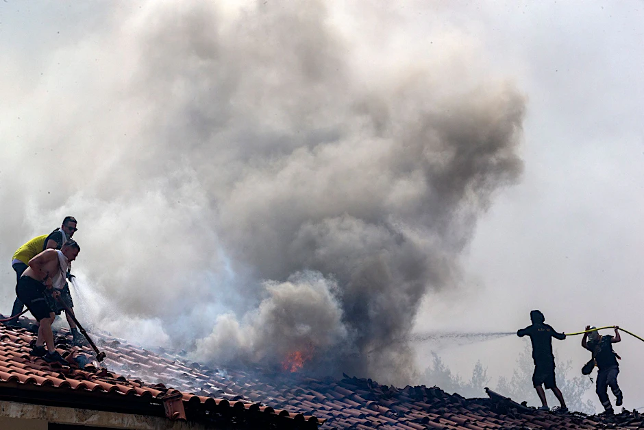 Freiwillige bekämpfen einen Waldbrand in der Nähe von Athen.  