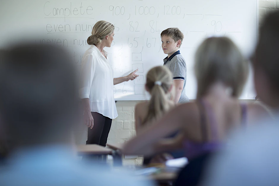 Eine Lehrerin redet mit einem Schüler im Unterricht