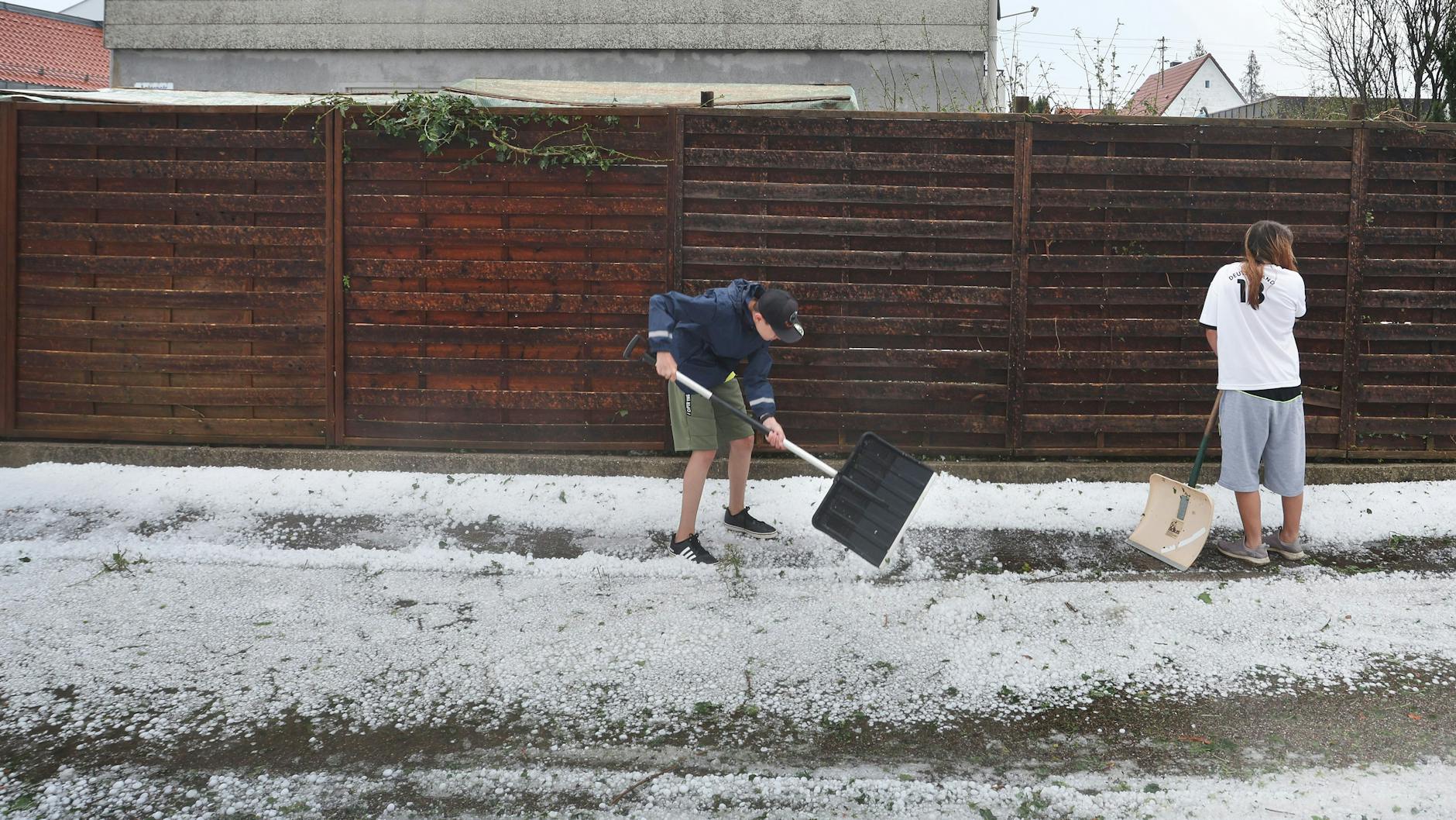 Kissing: Nach dem Unwetter schaufeln Anwohner Hagel vom Gehsteig. Der Deutsche Wetterdienst (DWD) warnte am Samstagabend weiter vor Unwettern im Süden Bayerns. 