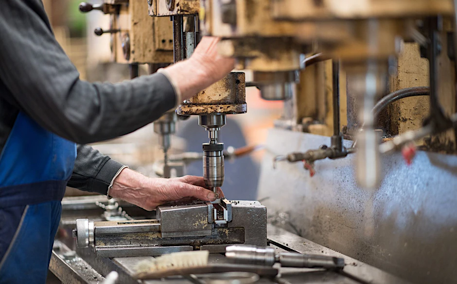 ARCHIV - Ein Mitarbeiter bedient in einer brandenburgischen Produktionshalle eine Maschine zur Verarbeitung von Metall. Die deutsche Wirtschaft ist nach dem frostigen Konjunkturwinter auch im Frühjahr nicht in Schwung gekommen.  