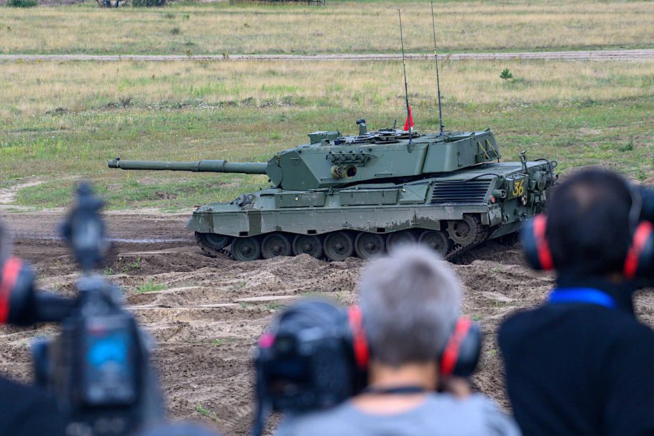 Medienvertreter mit Gehörschutz beobachten auf dem Truppenübungsplatz Klietz eine Übung ukrainischer Soldaten mit einem Kampfpanzer vom Typ Leopard 1 A5.