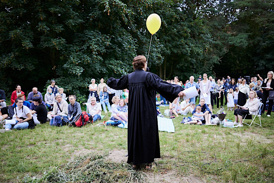 Eine Pastorin begrüßt die Gäste beim Tauffest der Evangelischen Kirche.  