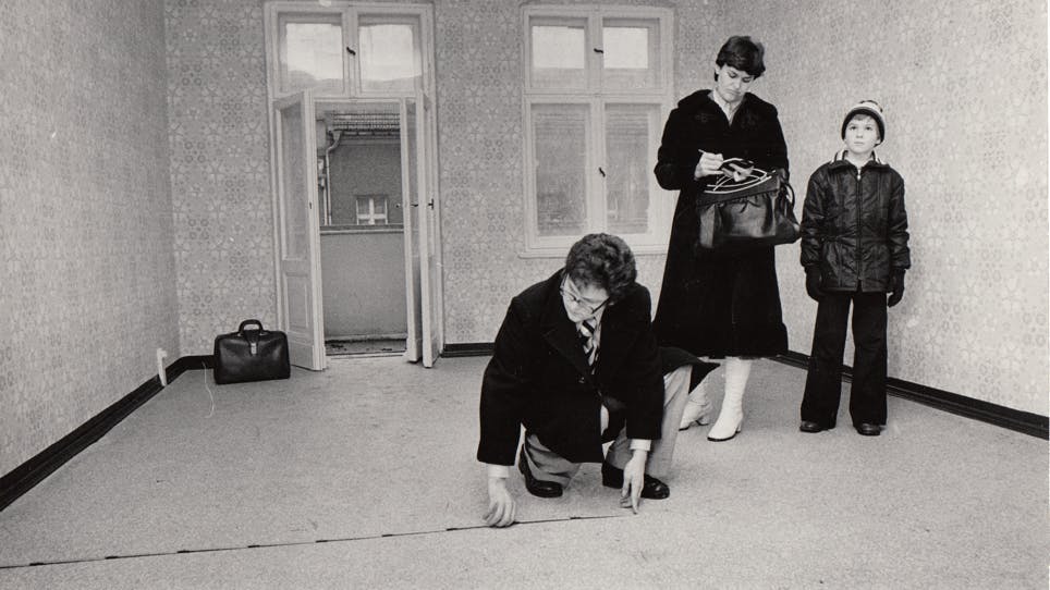 Eine Familie besichtigt ihre neue Wohnung. Der Vater vermisst schon den Raum. Im Osten Berlins war das ein Ereignis, vernünftige Wohnungen waren selten. 