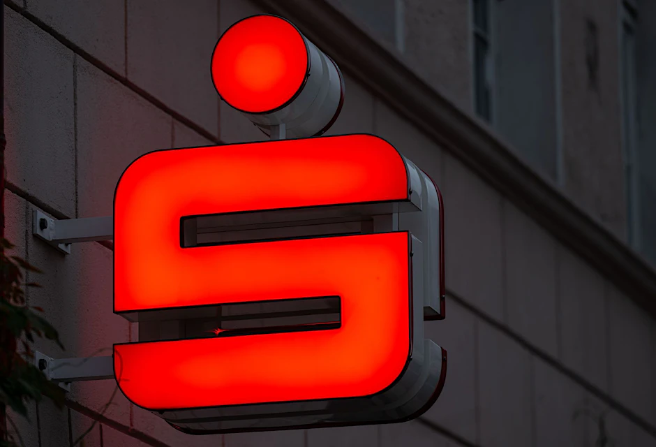 ARCHIV - Das Logo der Sparkasse leuchtet in einer Fußgängerzone der Lutherstadt Wittenberg.  