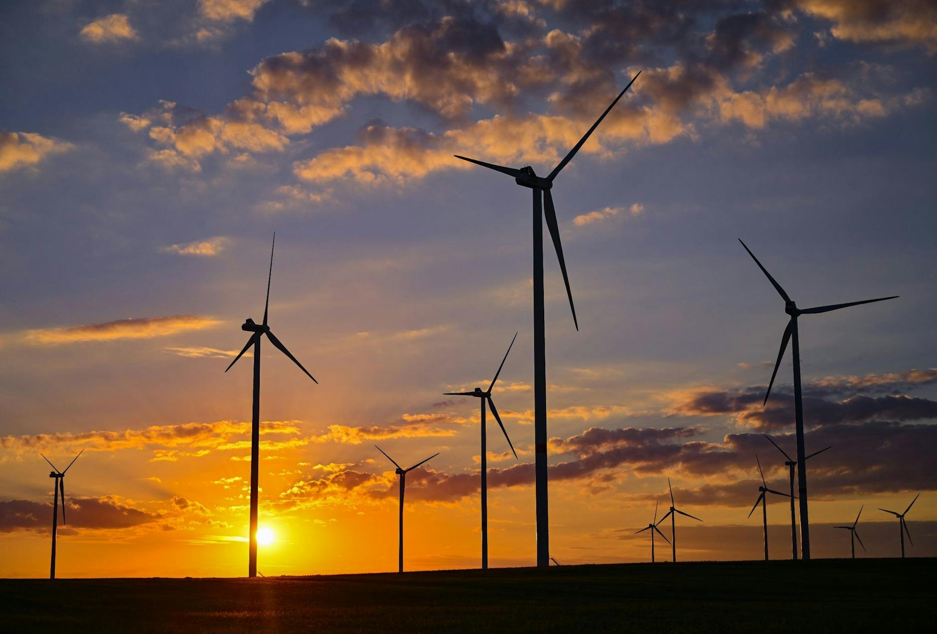 ARCHIV - Die Sonne geht hinter dem Windenergiepark «Odervorland» in Jacobsdorf unter.