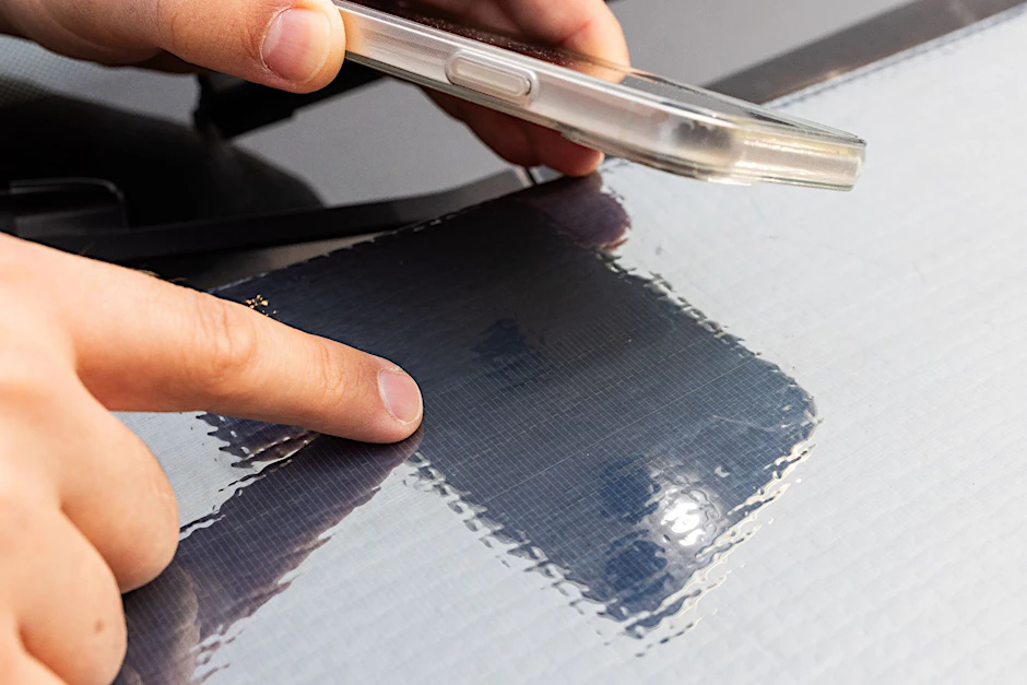 Ein Forscher des Fraunhofer ISE zeigt auf die Struktur der Solarzellen auf einer Motorhaube.&nbsp;