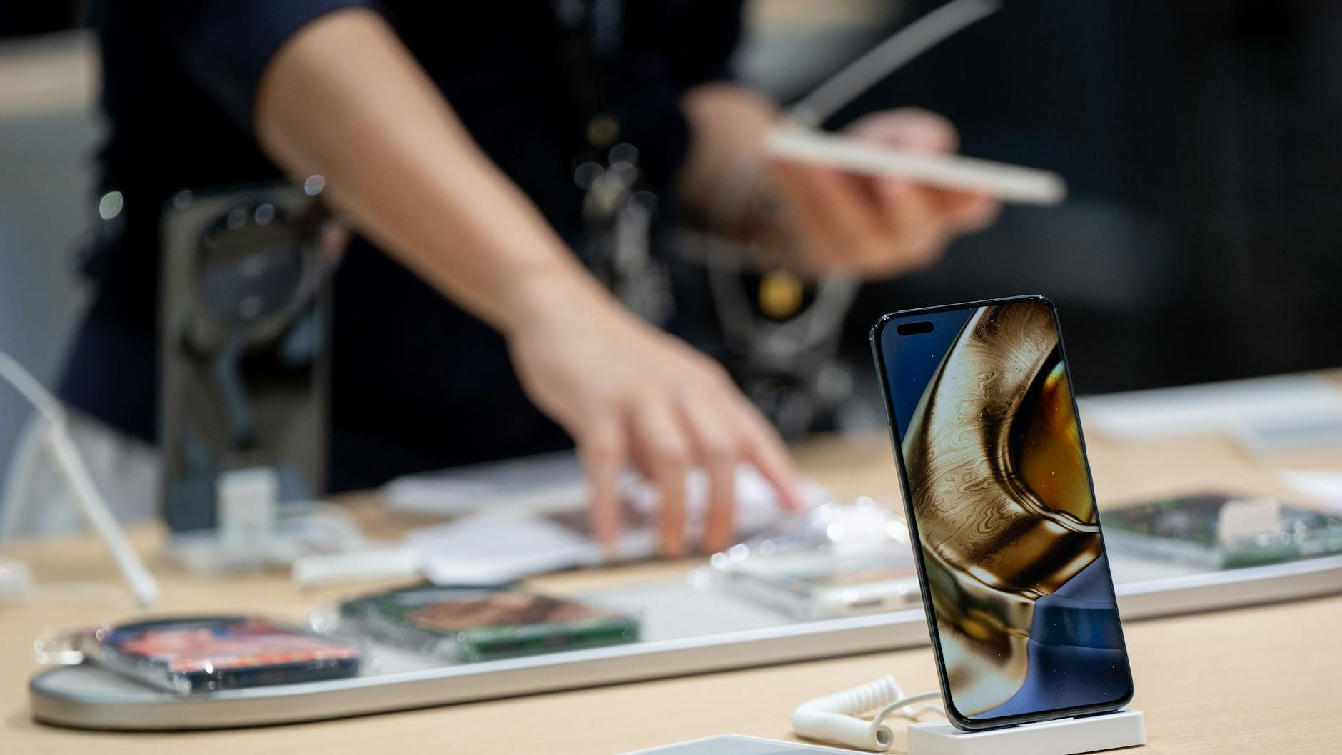 Eine Frau bereitet auf der Ifa in der Messe Berlin den Stand des Herstellers Honor vor.