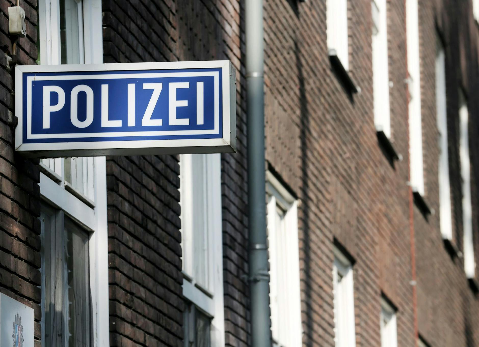 ARCHIV - Ein Schild mit der Aufschrift «Polizei» hängt an einem Polizeipräsidium.
