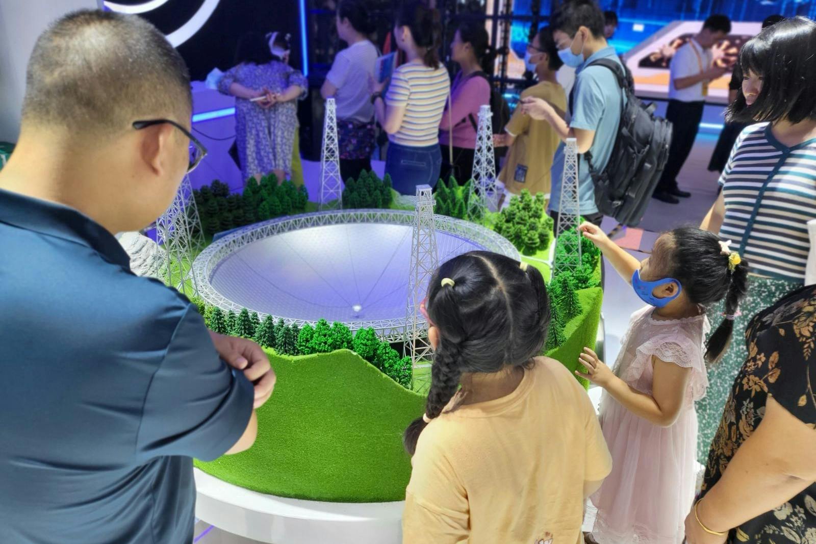 Kinder am Modell eines chinesischen Großmessgeräts für kosmische Strahlung.