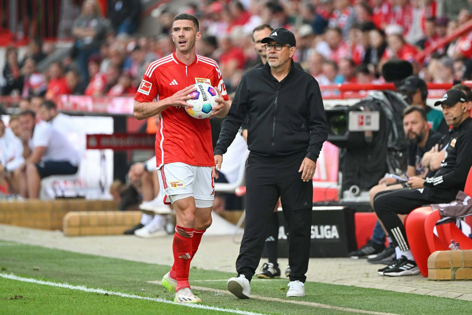Robin Gosens sondiert vorm Einwurf das Spielfeld nach Abnehmern, Trainer Urs Fischer (r.) sucht auch die beste Anspielstation.