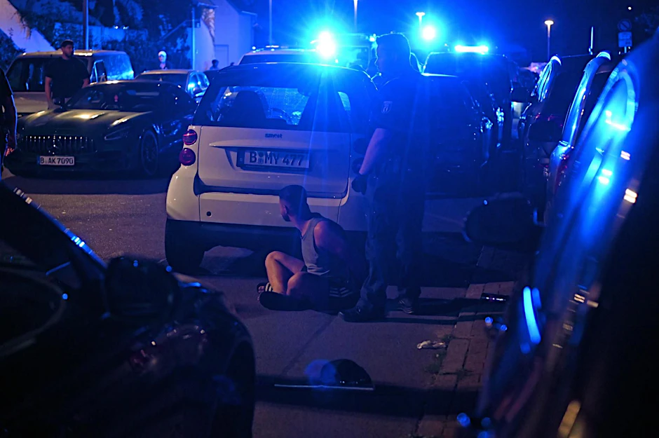 In Berlin-Neukölln kam es in der Nacht zum Mittwoch zu einer Schlägerei mit etlichen Beteiligten, bei der auch Beamte verletzt wurden. Ein Mann in Badelatschen sitzt in Gewahrsam am Boden.&nbsp;