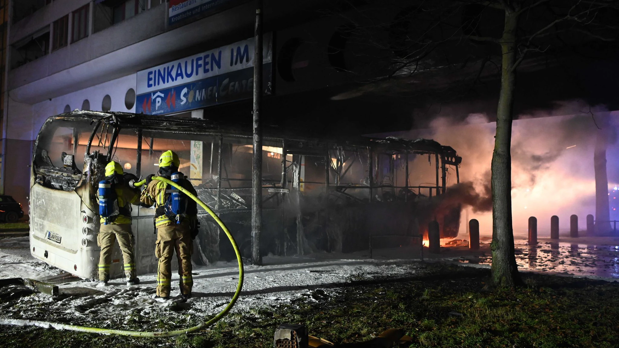 Einsatzkräfte der Feuerwehr löschen in der Silvesternacht an der Sonnenallee im Bezirk Neukölln einen brennenden Bus, der von Unbekannten angezündet worden war.&nbsp;&nbsp;