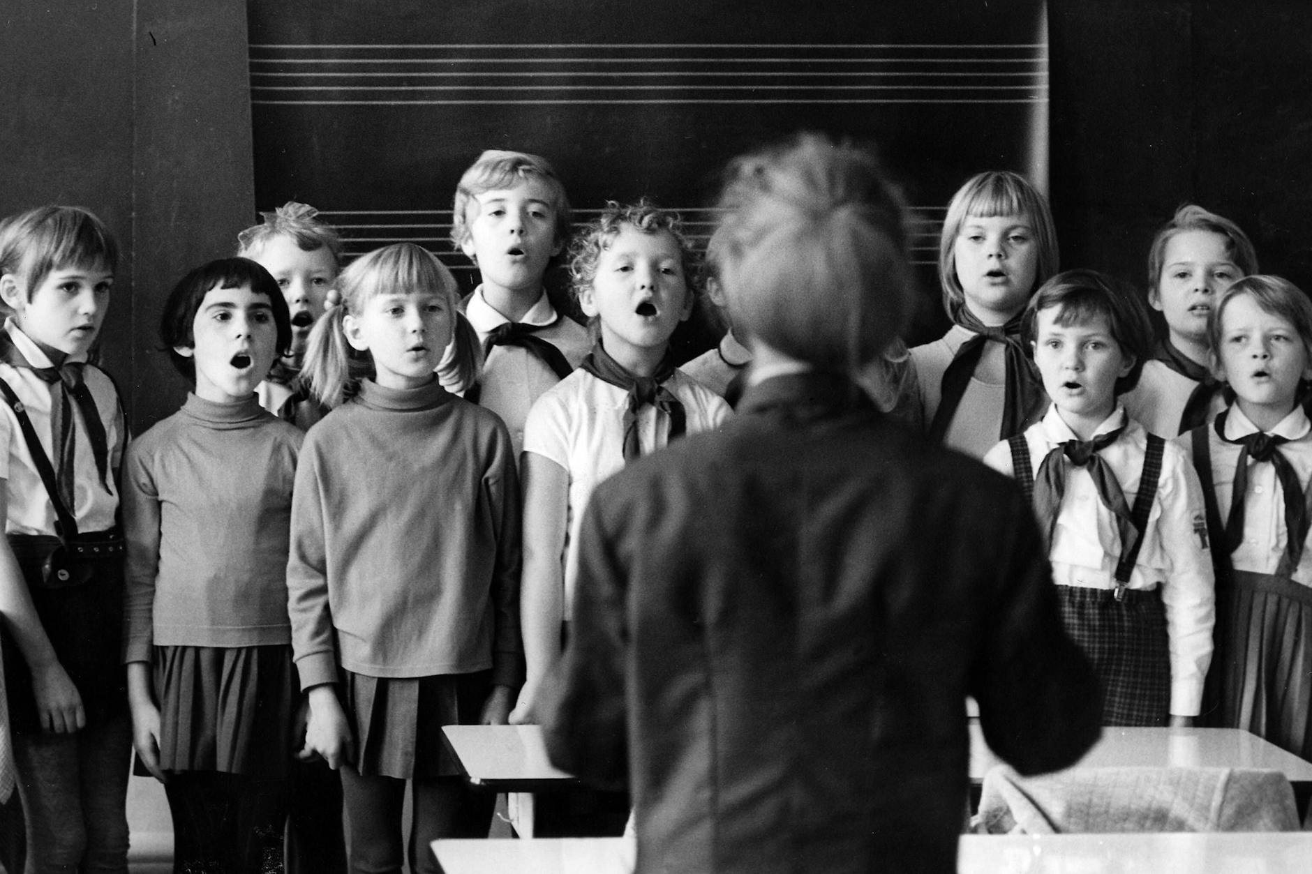 1970: Pioniere und Lehrerin singen ein Lied zum Start in den Unterrichtstag.