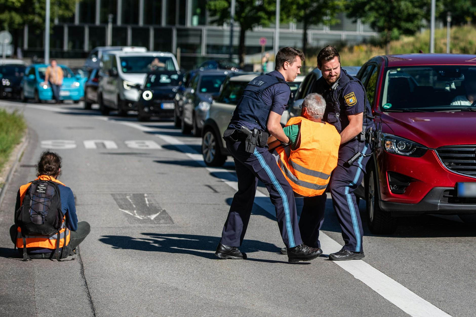 Diese Woche in München: Polizisten entfernen Blockierer der Letzten Generation von der Straße. Die Teilnehmer waren Teil einer Straßenblockade, die sich gegen die IAA gerichtet hat.