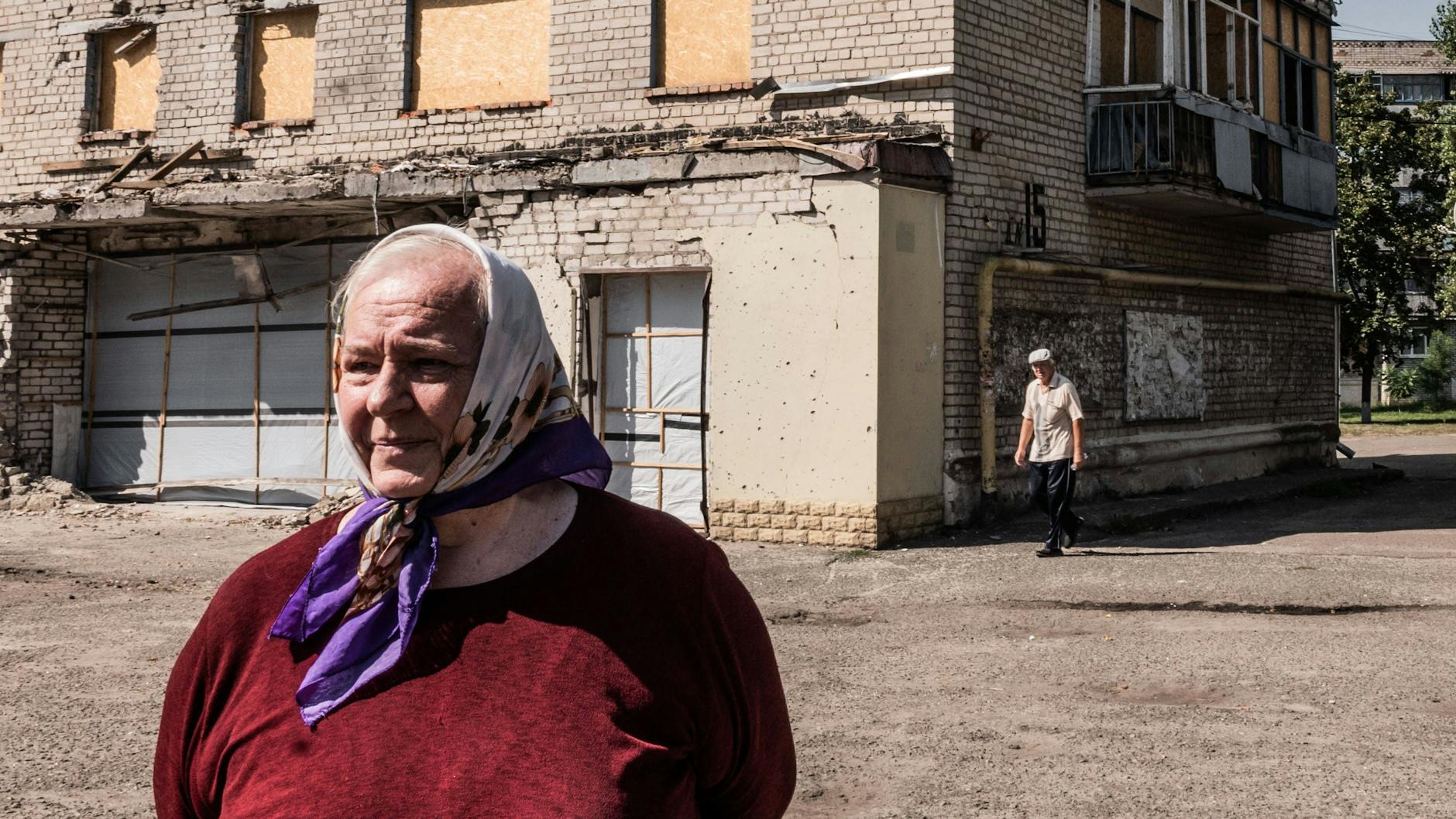 Zivilistin vor ihrem zerbombten Wohngebäude im kleinen ukrainischen Dorf Kuryliwka.